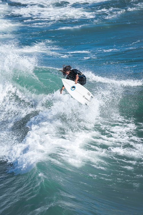 Pessoa Fazendo Acrobacias Na Prancha De Surfe