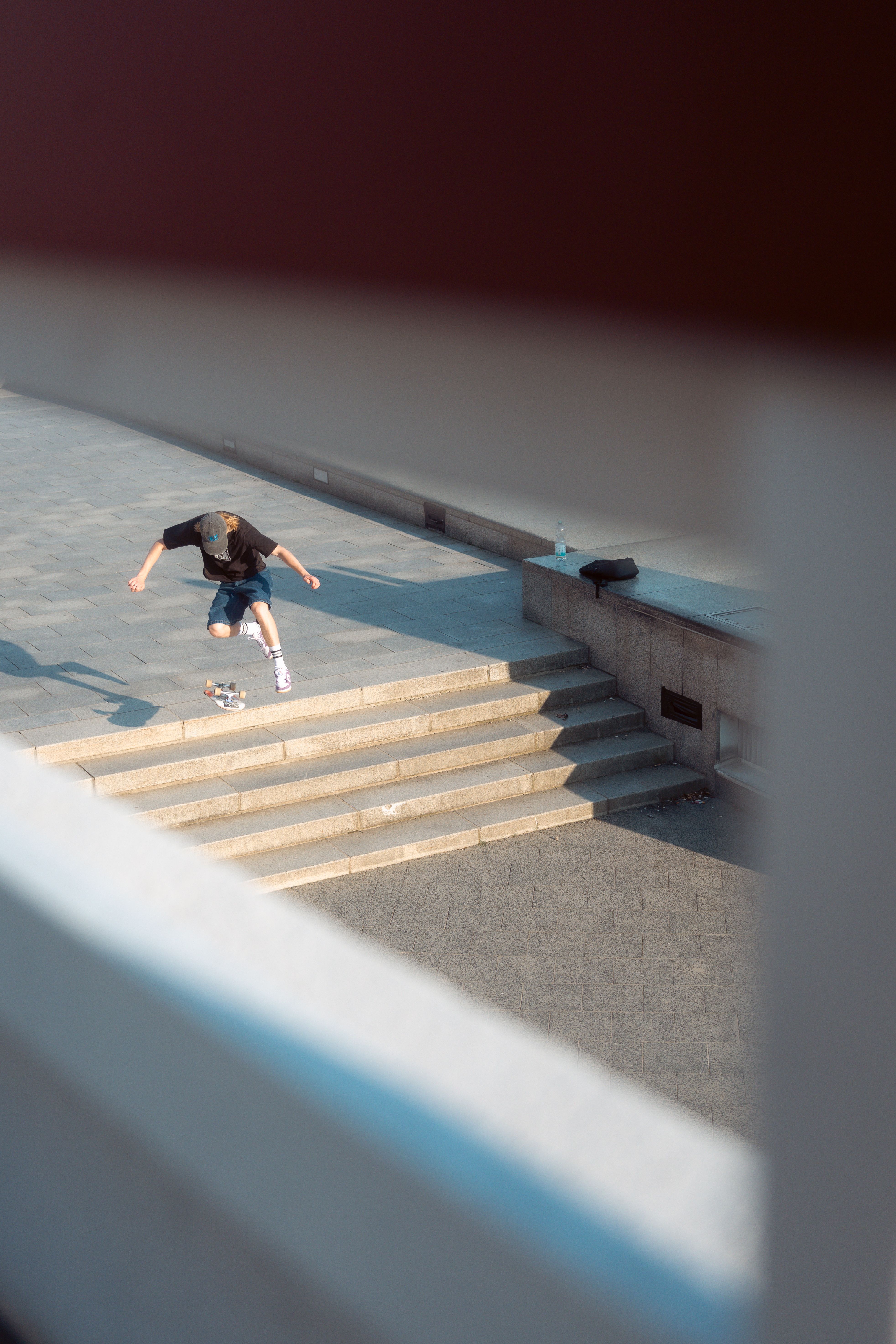 Dynamic shot of a skateboarder performing an ollie on city stairs in Berlin. Captures youth and motion.