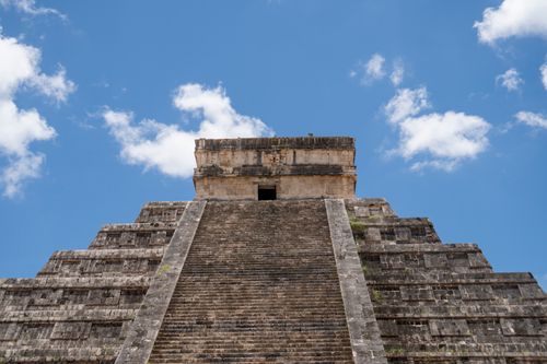 Free El Castillo pyramid under blue skies at Chichén Itzá, showcasing Mayan architecture. Stock Photo