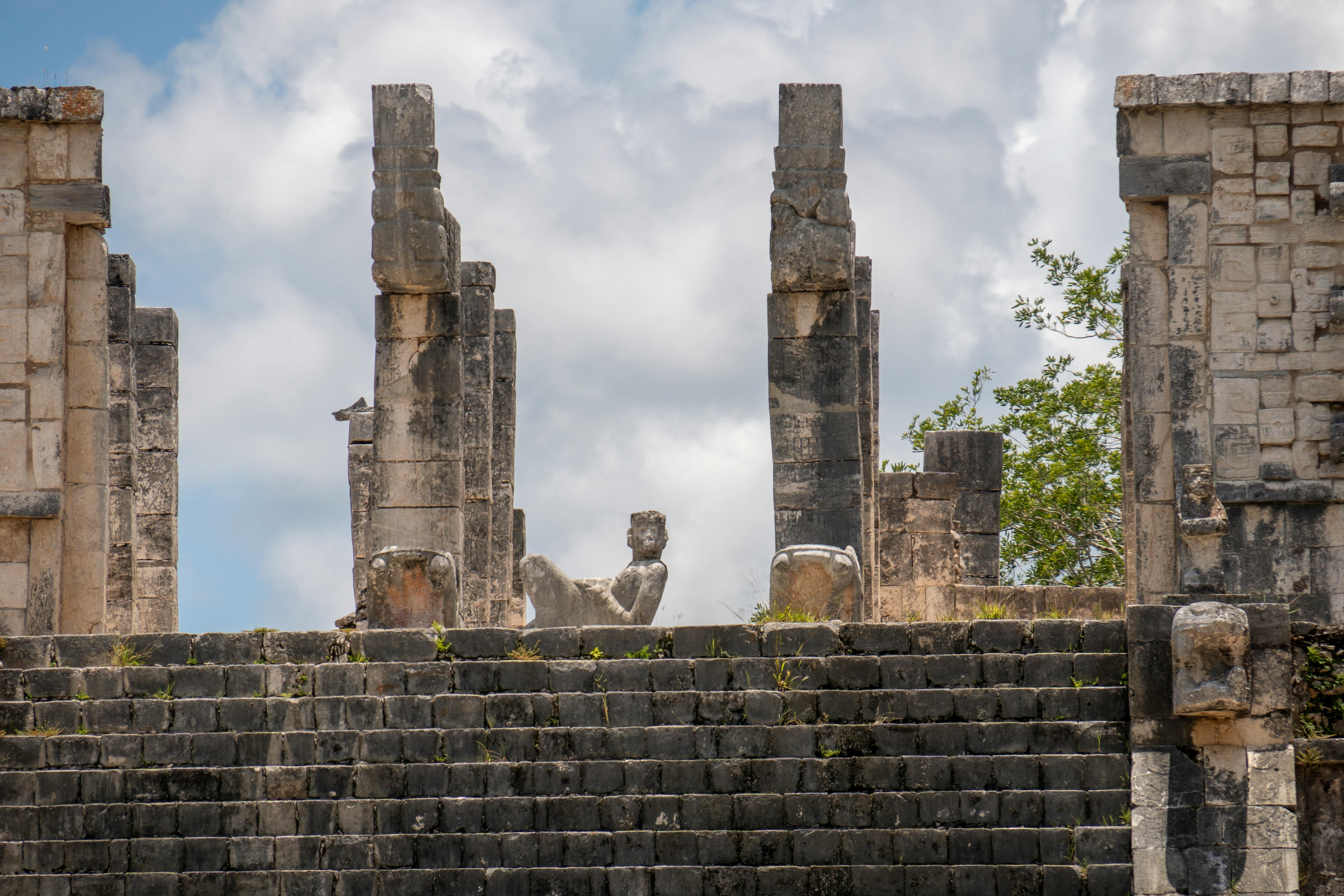 ancient mayan civilization historical tour packages for agencies - Ancient stone ruins at Chichén-Itzá, showcasing Mayan architecture under a cloudy sky.
