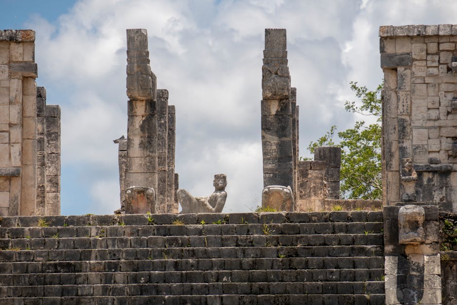 ancient mayan civilization historical tour packages for agencies - Ancient stone ruins at Chichén-Itzá, showcasing Mayan architecture under a cloudy sky.
