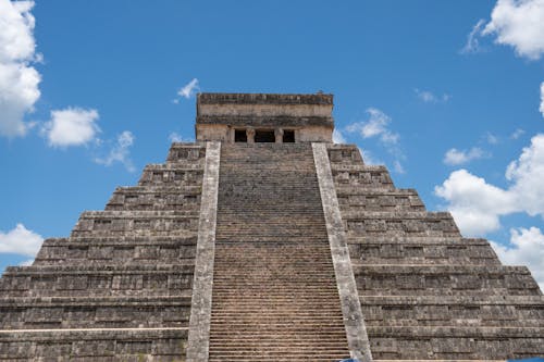 Free El Castillo pyramid at Chichén Itzá under a clear blue sky. A quintessential Mayan archaeology site highlighting ancient architecture. Stock Photo