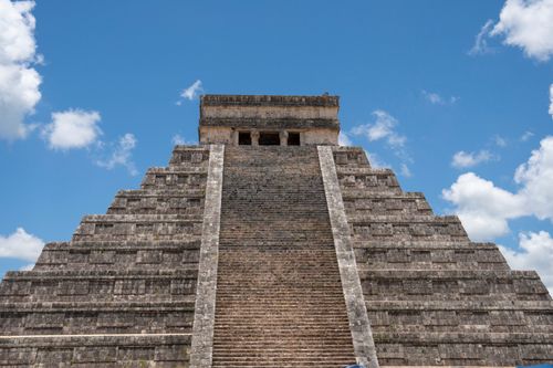 Free El Castillo pyramid at Chichén Itzá under a clear blue sky. A quintessential Mayan archaeology site highlighting ancient architecture. Stock Photo