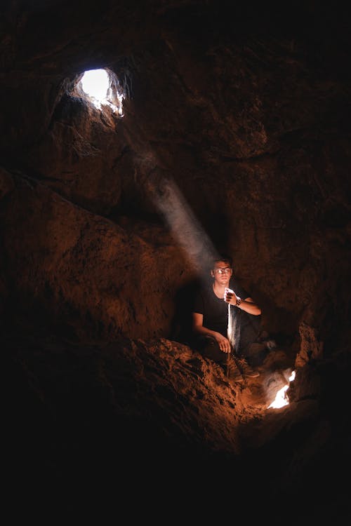 Photo D'un Homme Assis à L'intérieur De Cavee