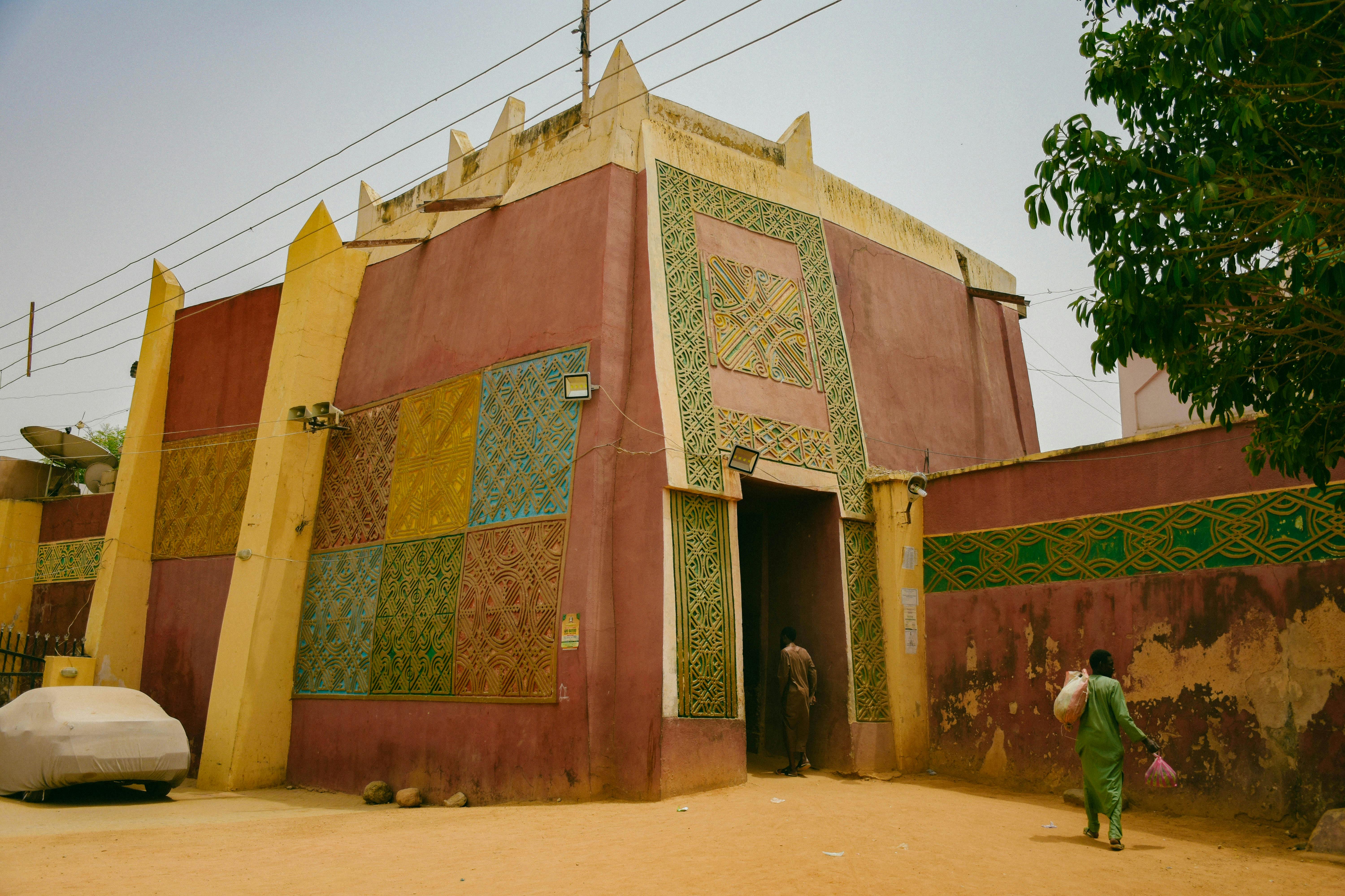 Colorful building with intricate patterns in an urban Nigerian setting, showcasing unique architecture and street life.