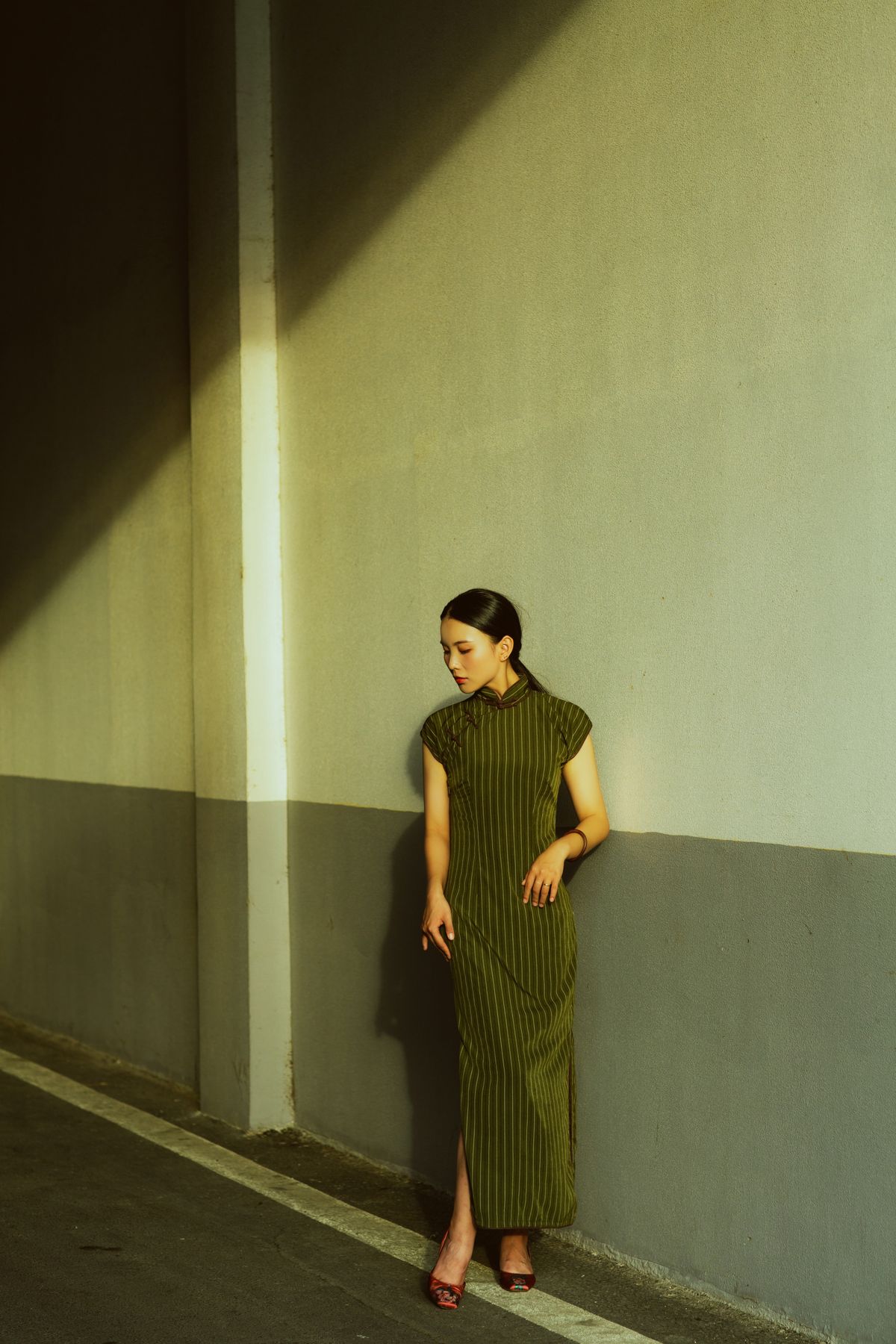 A woman in a long dress leaning against a wall · Free Stock Photo