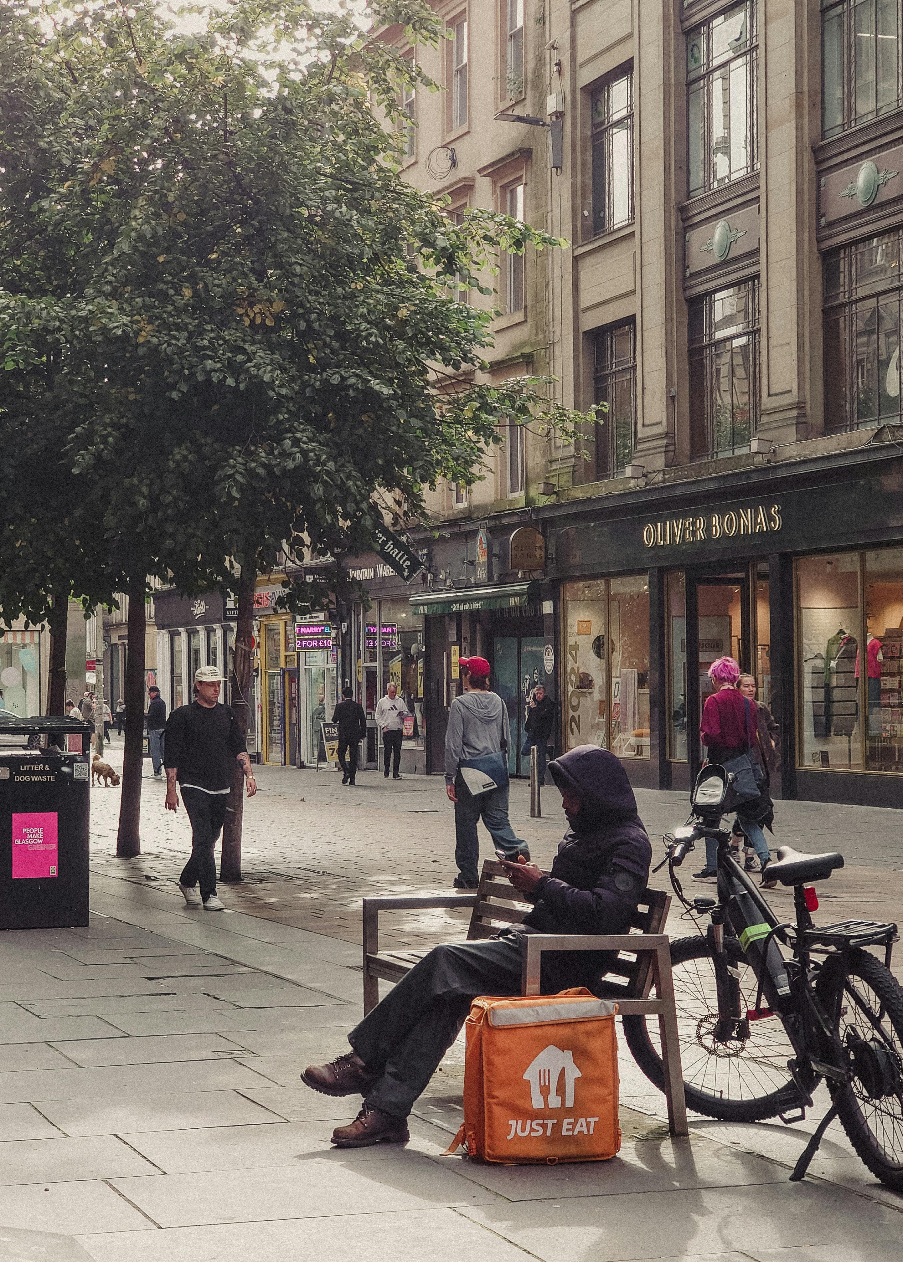 a man sitting on a bench in front of a store