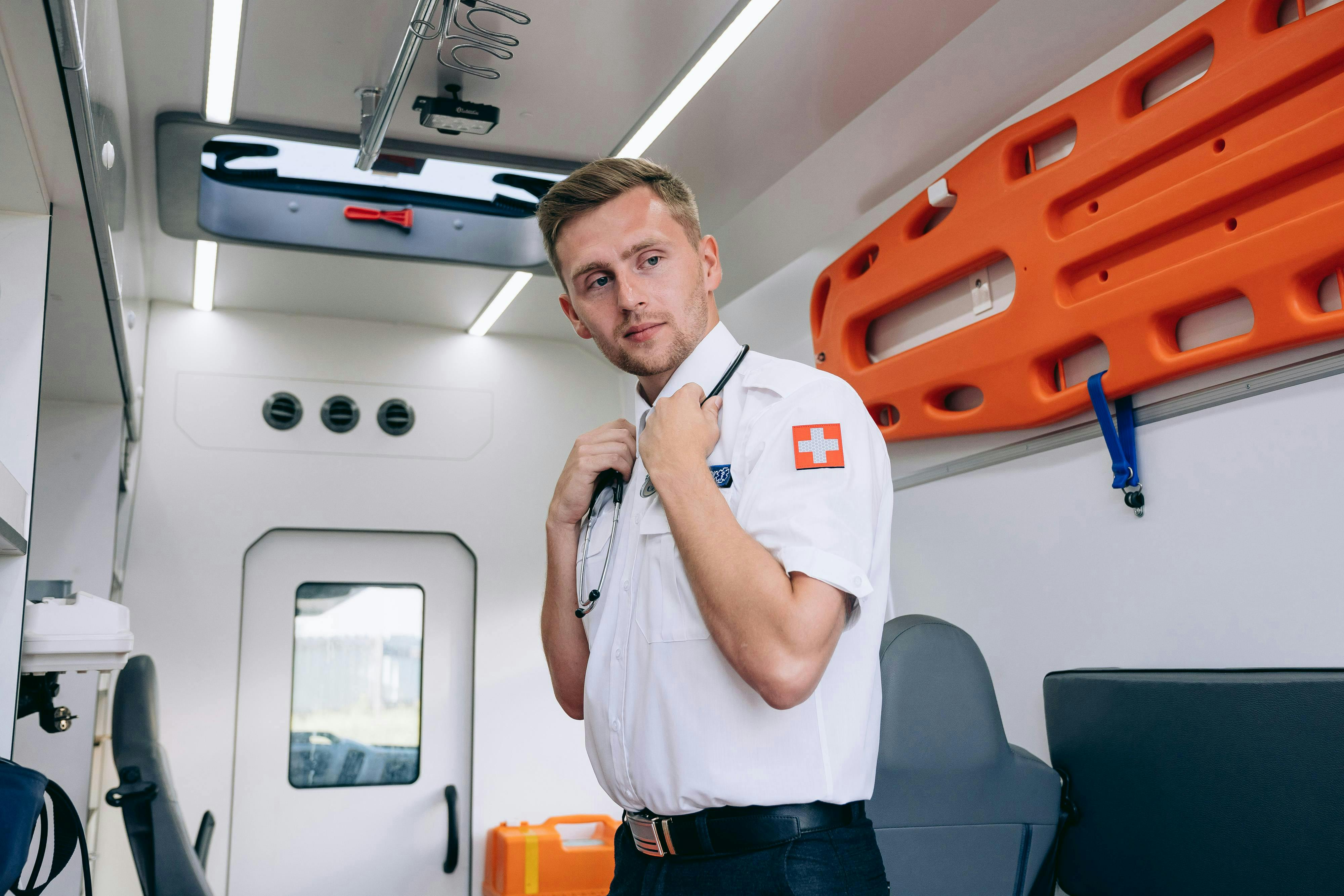 paramedic with stethoscope standing in the back of an ambulance