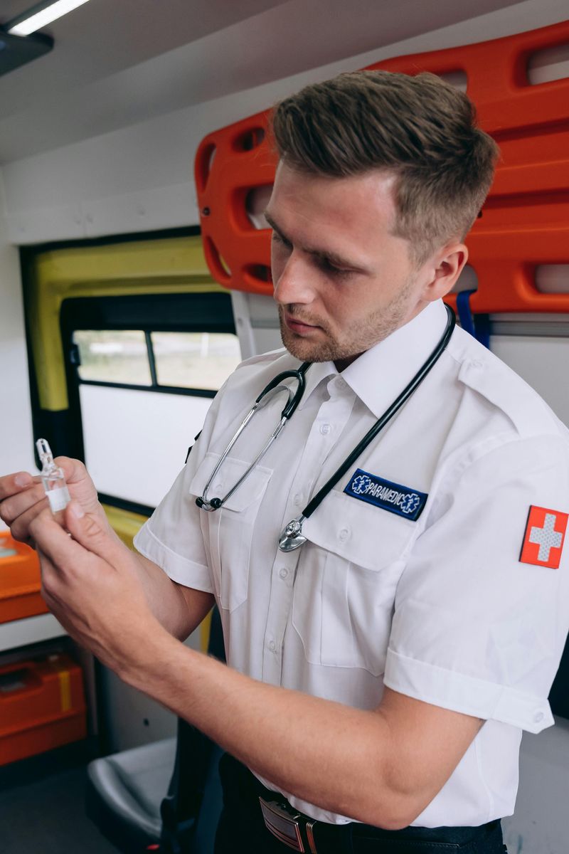 A paramedic checking a medicine ampoule inside an ambulance
