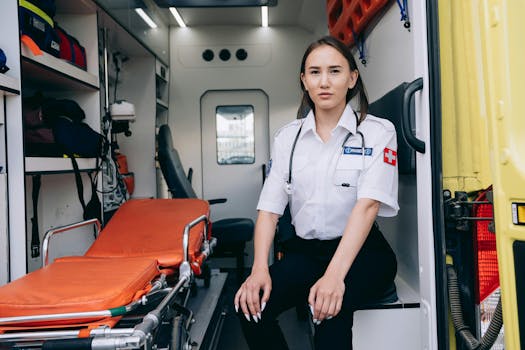 Female paramedic sitting inside an ambulance, ready for emergency response.