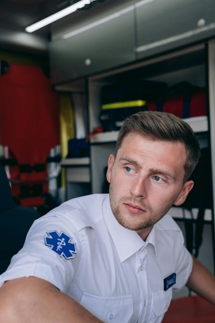 Fotomural Retrato de un paramédico sentado dentro de una ambulancia, mostrando el uniforme y equipo de EMS.