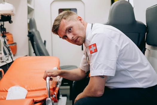 A paramedic in uniform inside an ambulance, adjusting a gurney for patient care.
