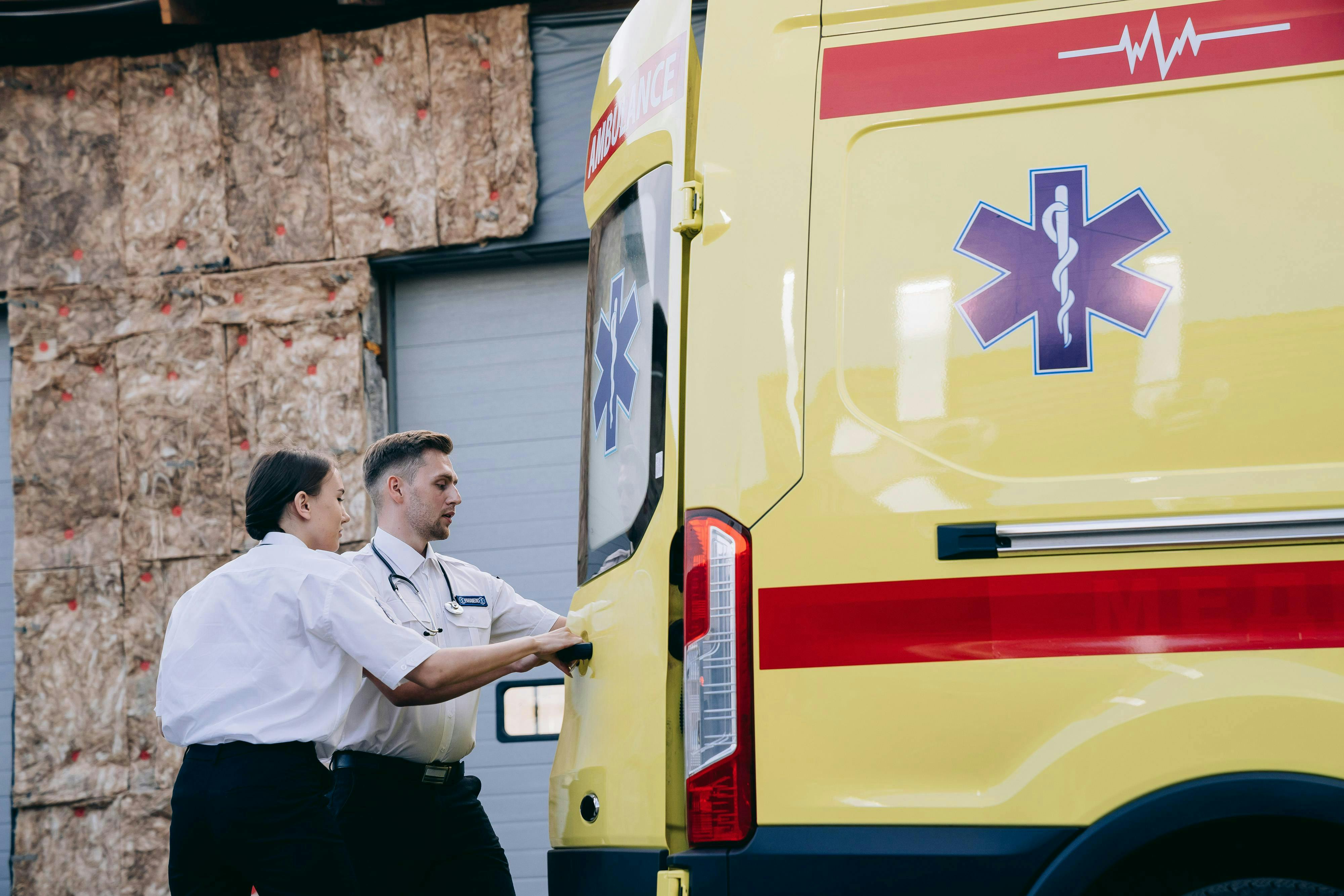 paramedics standing behind ambulance