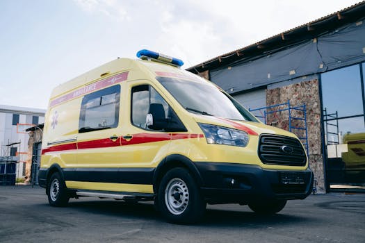 Bright yellow ambulance parked outdoors in an urban environment.