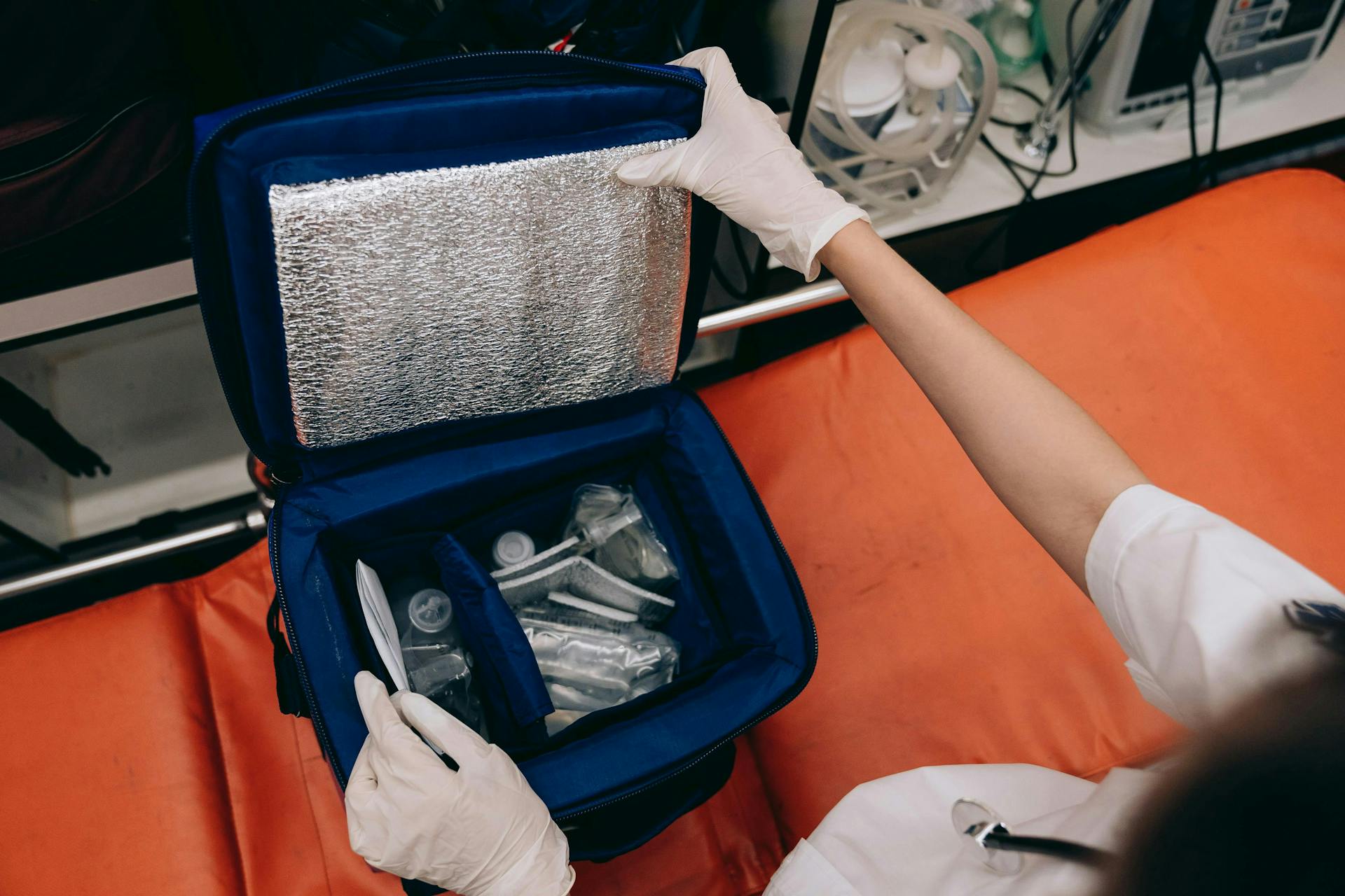 A person holding a blue bag with medical supplies