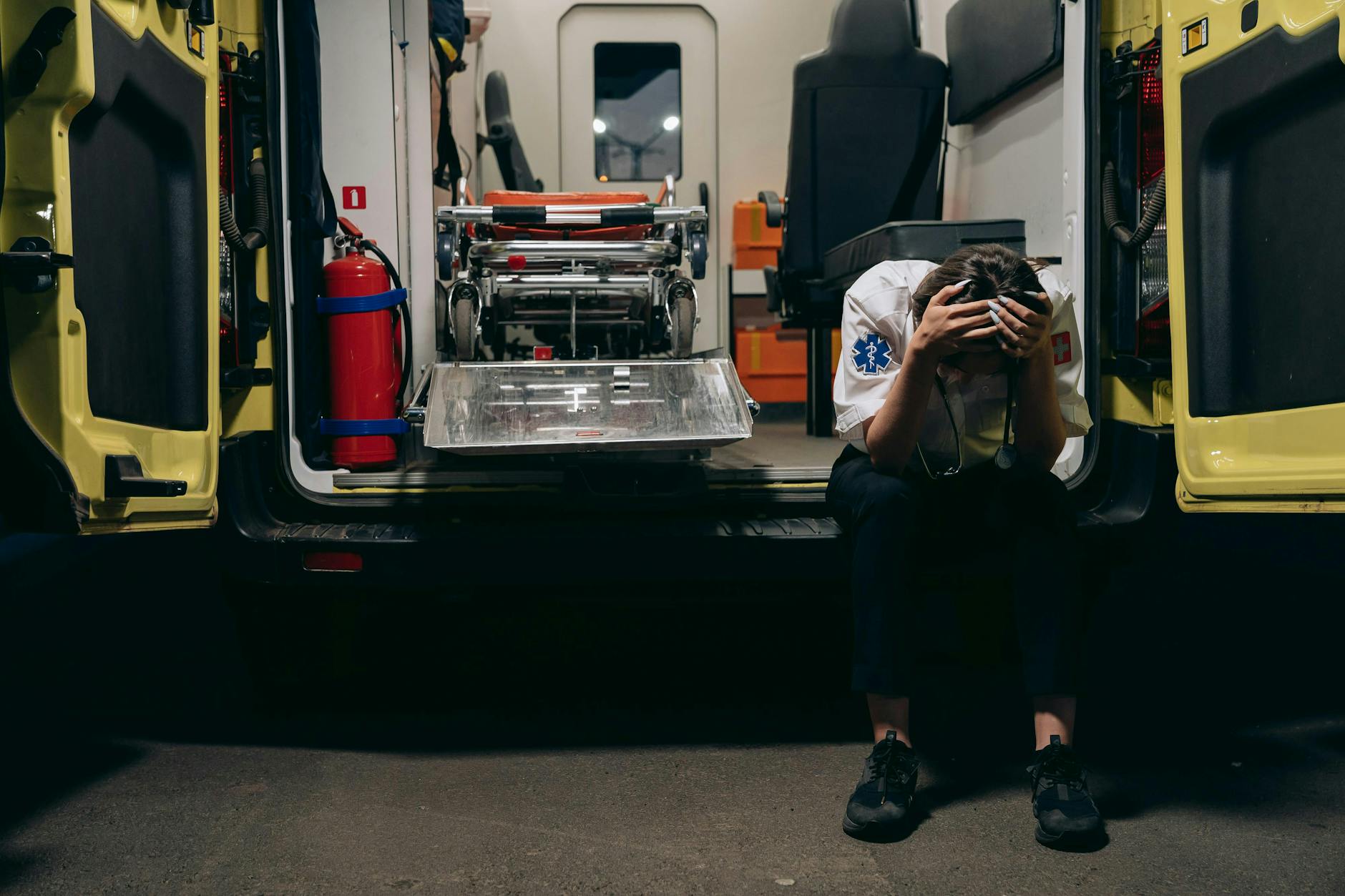 https://www.pexels.com/photo/paramedic-sitting-on-the-bumper-of-an-ambulance-with-head-in-hands-28123722/
