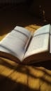 A book on a bed with sunlight shining through it