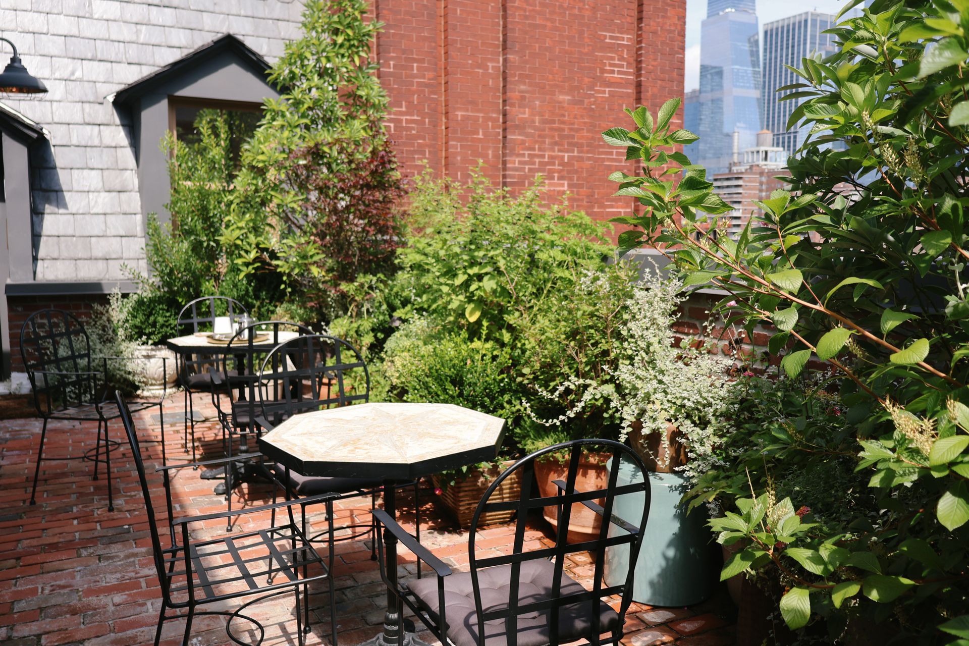 A patio with tables and chairs and plants