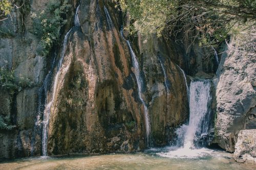 Free Serene waterfall cascading down rocky cliffs in Malatya, Türkiye, surrounded by lush greenery. Stock Photo