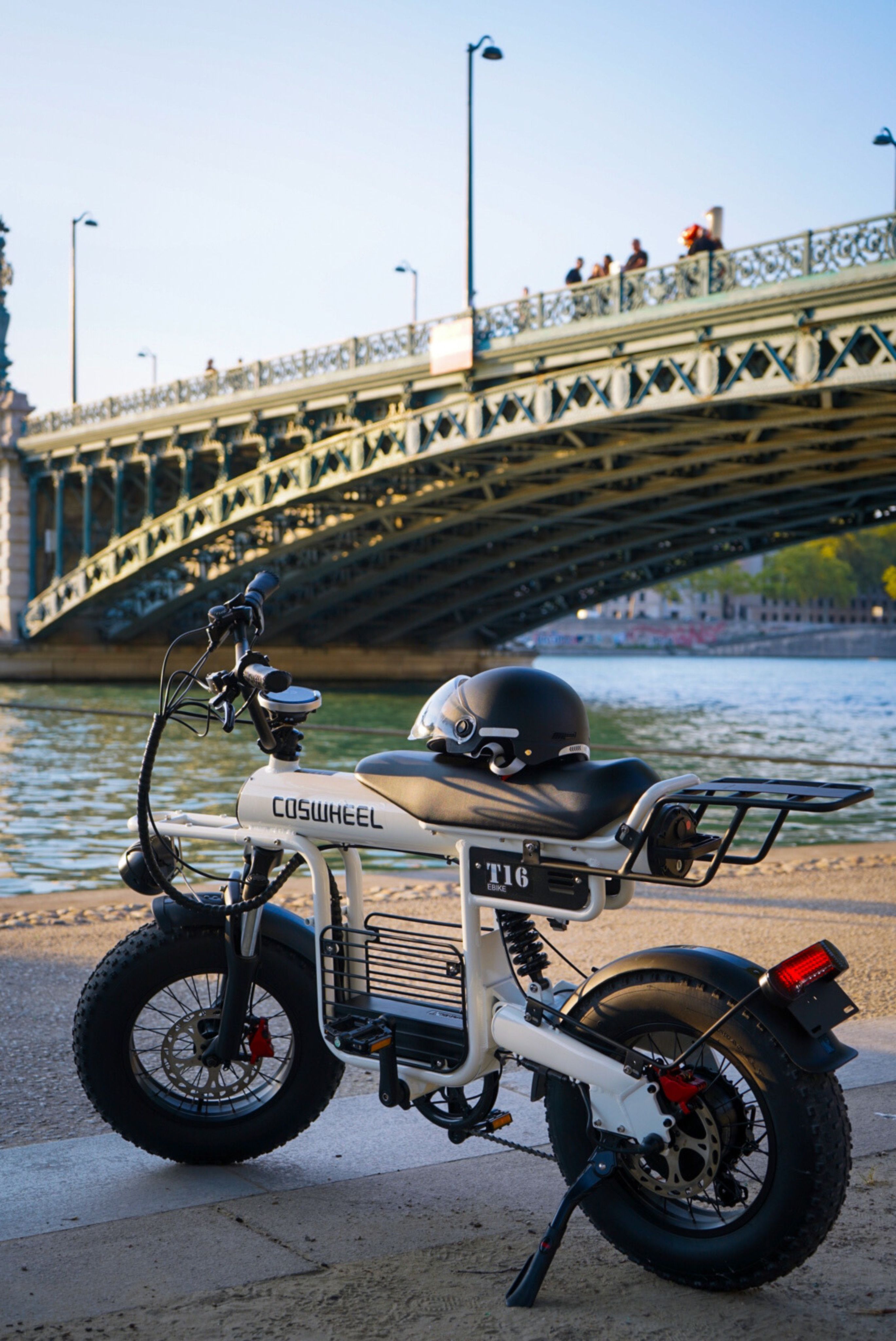 A motorcycle parked near a bridge with a river in the background · Free ...