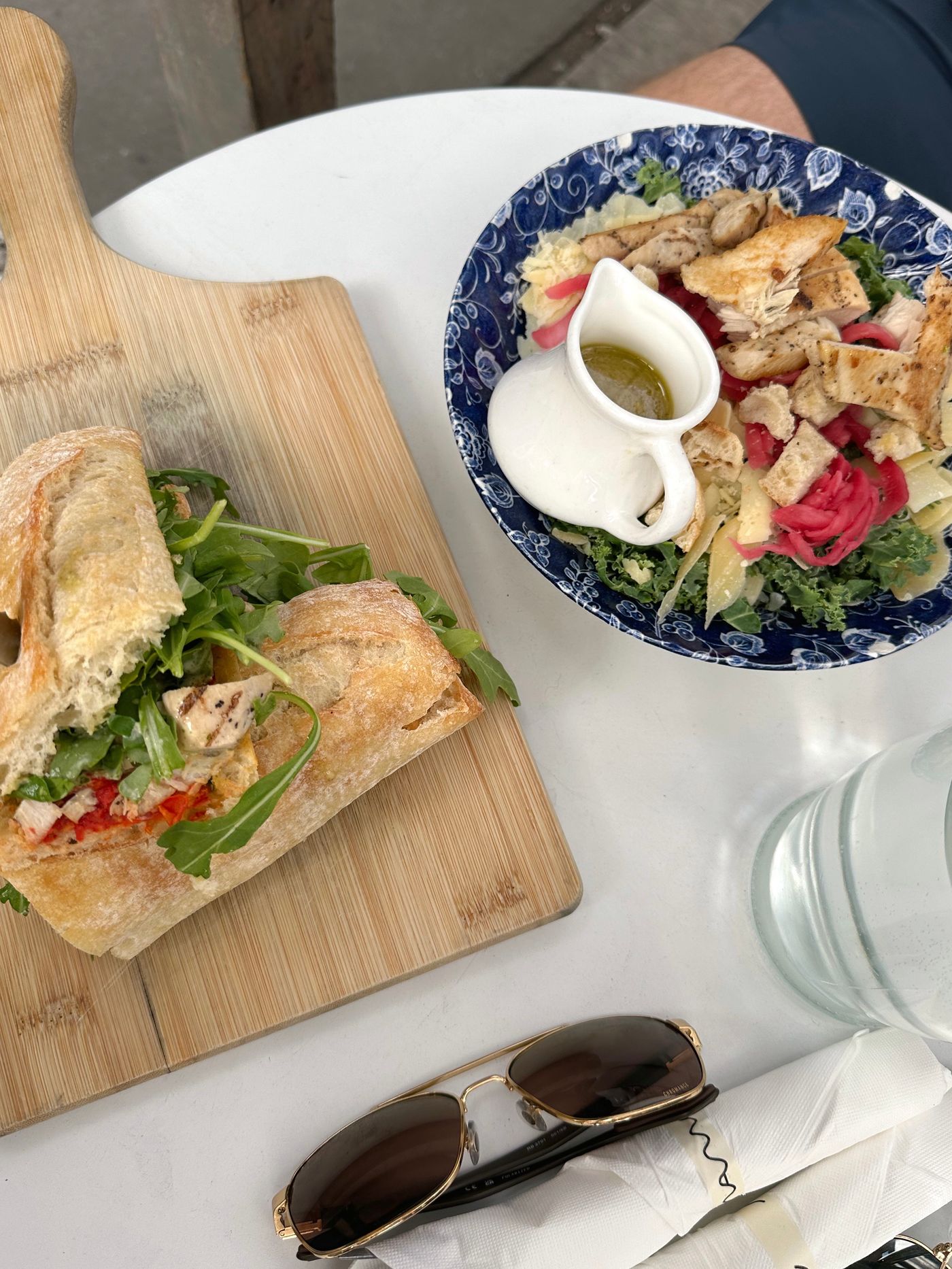Chicken salad sandwich and greens on a wooden board