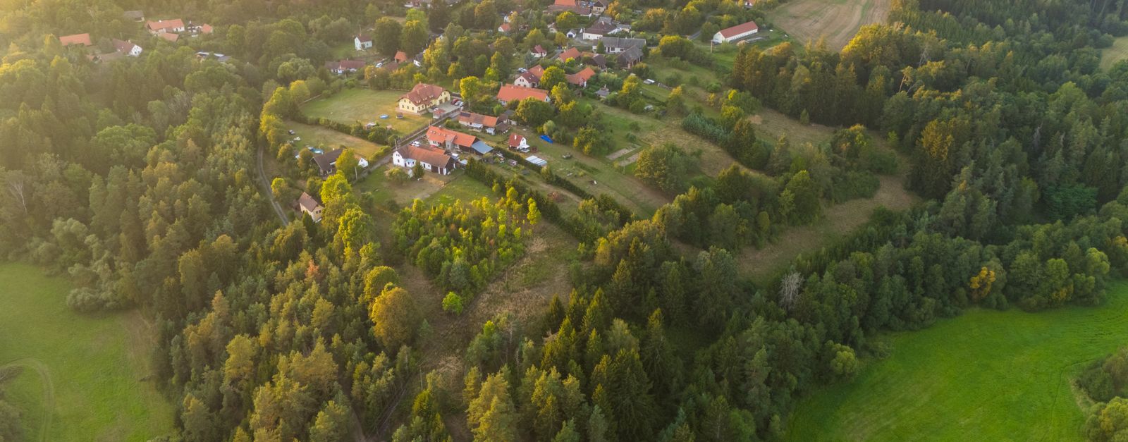 Charming aerial landscape of Čestín village during golden hour with lush greenery.