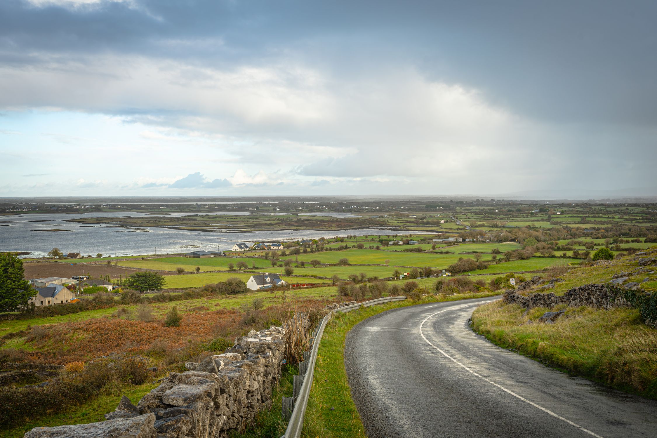 Explore the breathtaking Burren landscape featuring a winding road leading to the sea in Ireland.