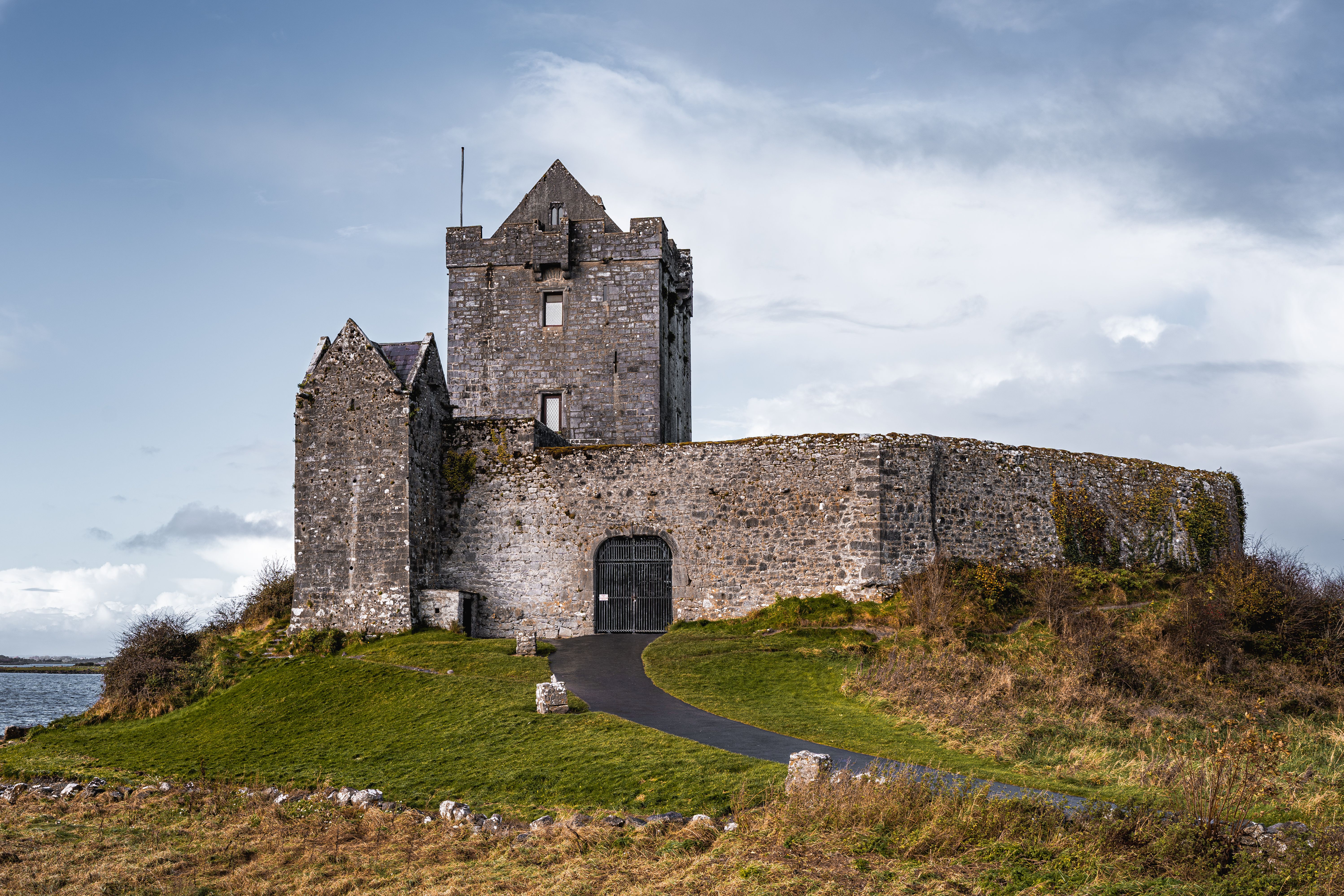 Explore the historic Dunguaire Castle in Kinvara, Ireland, surrounded by lush greenery.