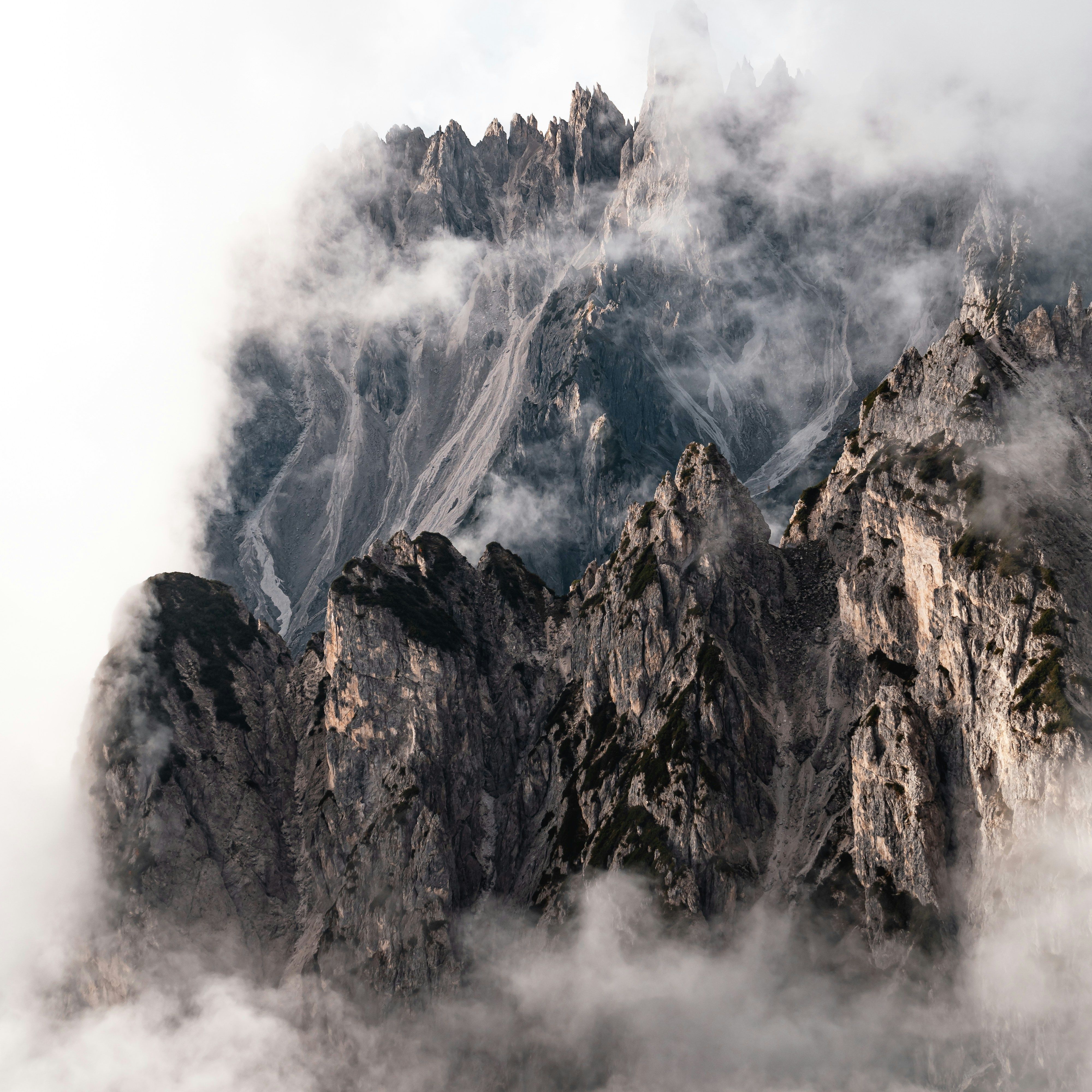 Majestic mountain peaks enveloped by fog creating a mystical landscape view.