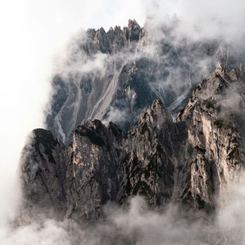 Majestic mountain peaks enveloped by fog creating a mystical landscape view.
