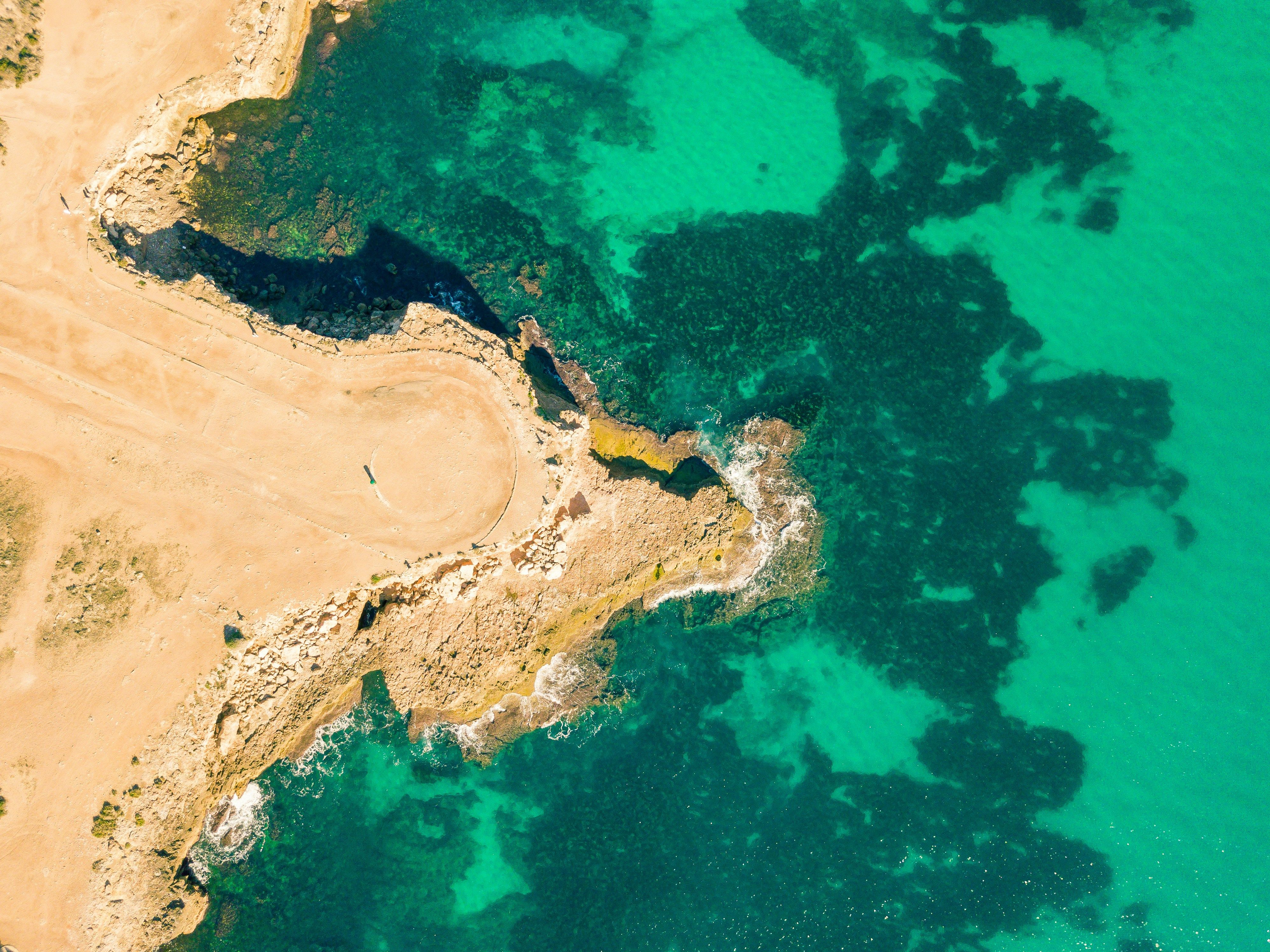 Wide white sand crescent at Coral Bay with limestone headlands at each end