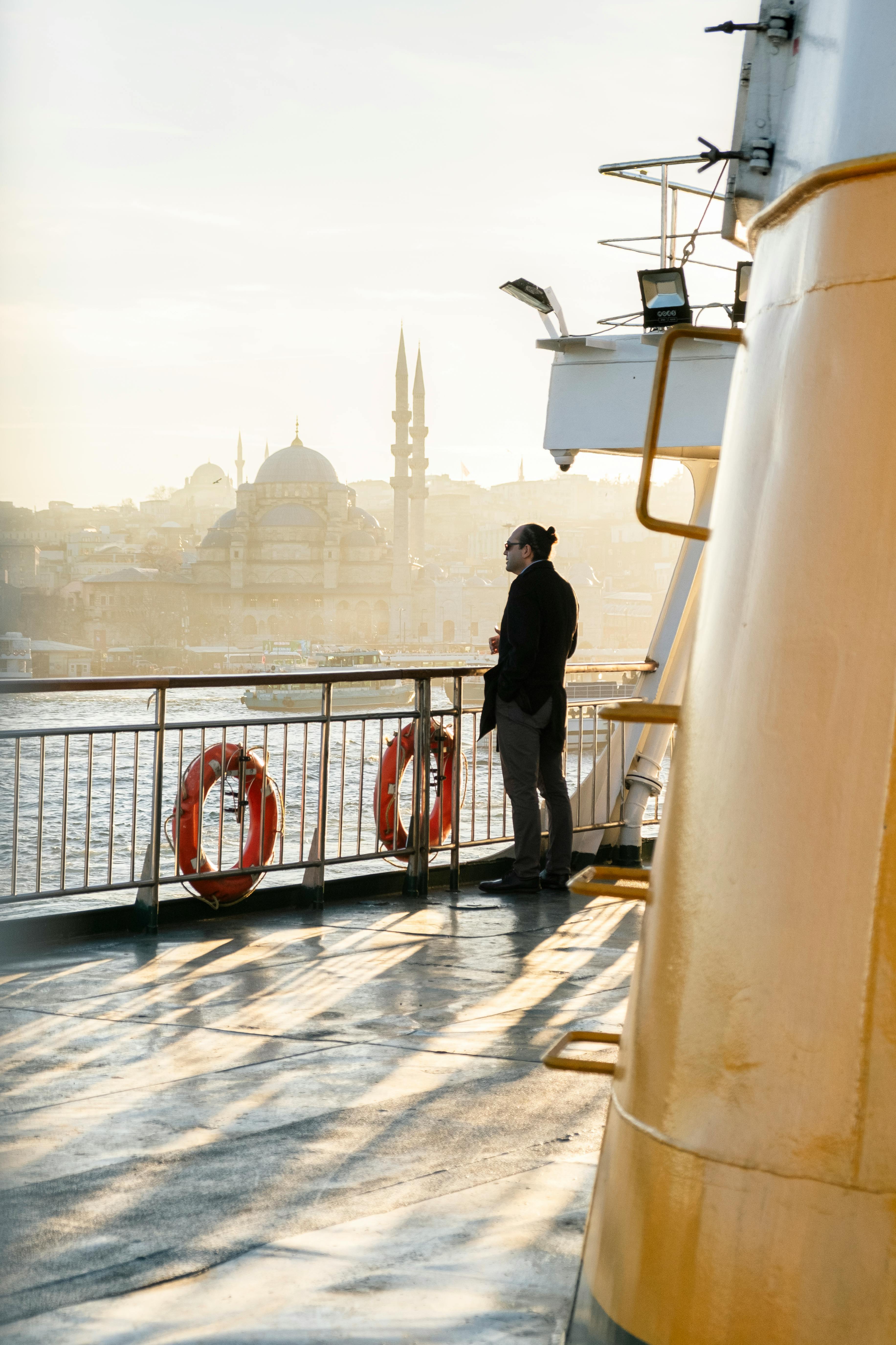 a man standing on the deck of a ship looking out at the water