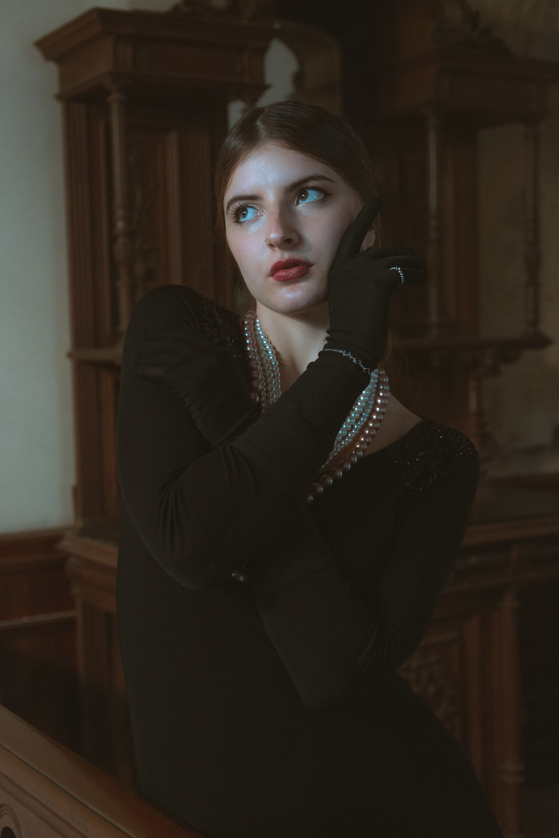 woman in little black dress with red lips and pearls