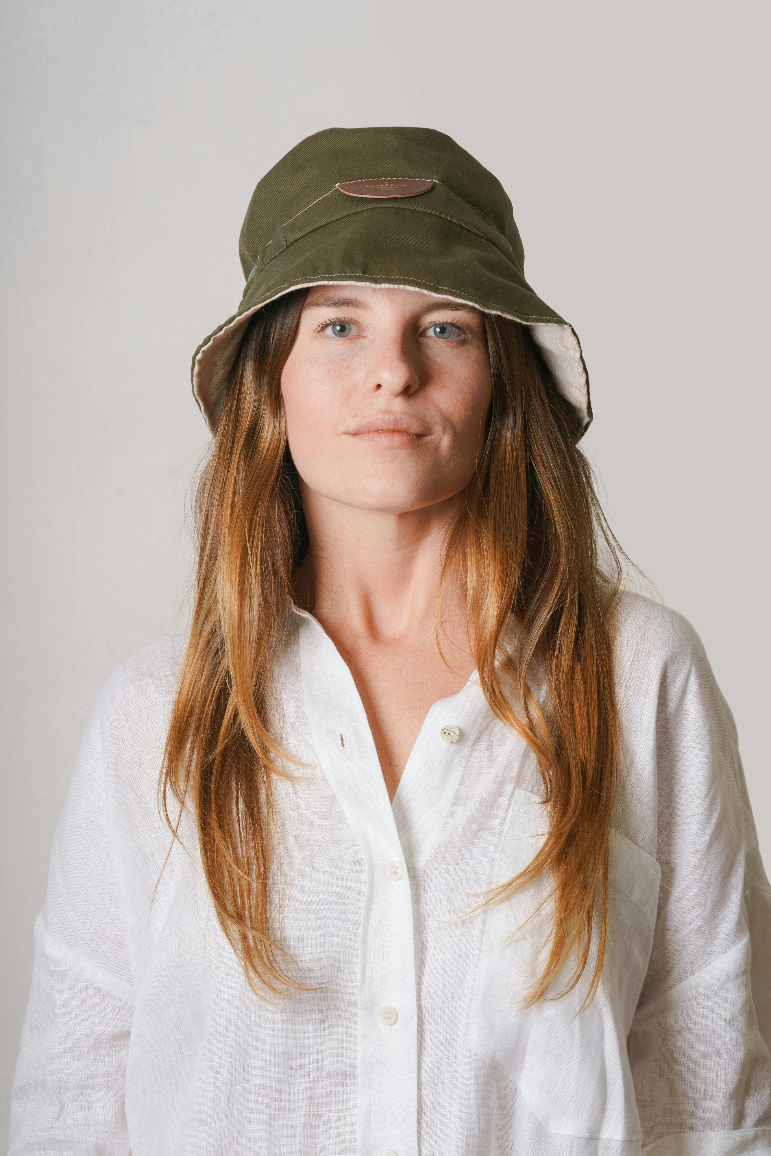 studio shot of a young woman wearing a shirt and a hat