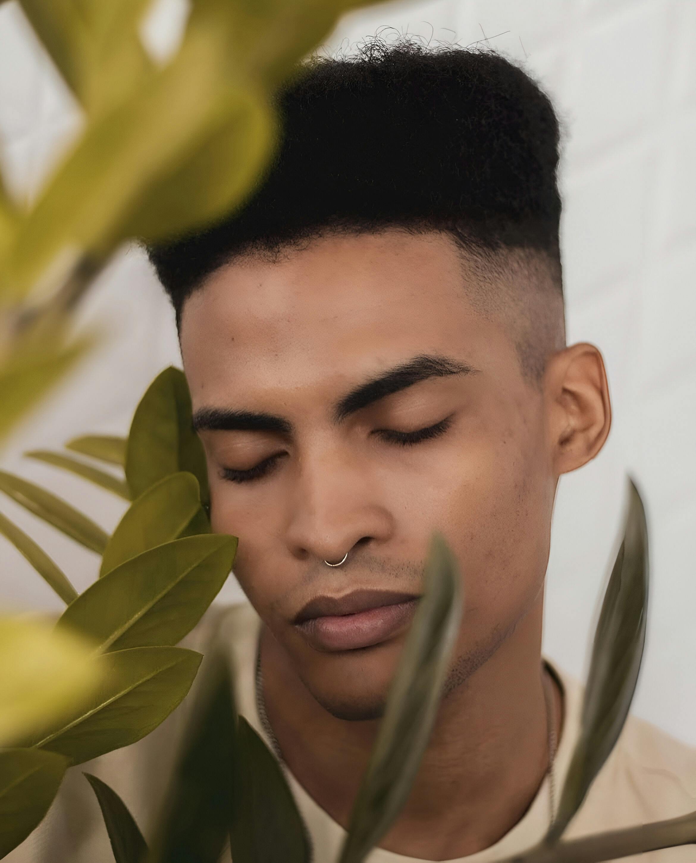 a man with a beard and eyes closed is looking at plants