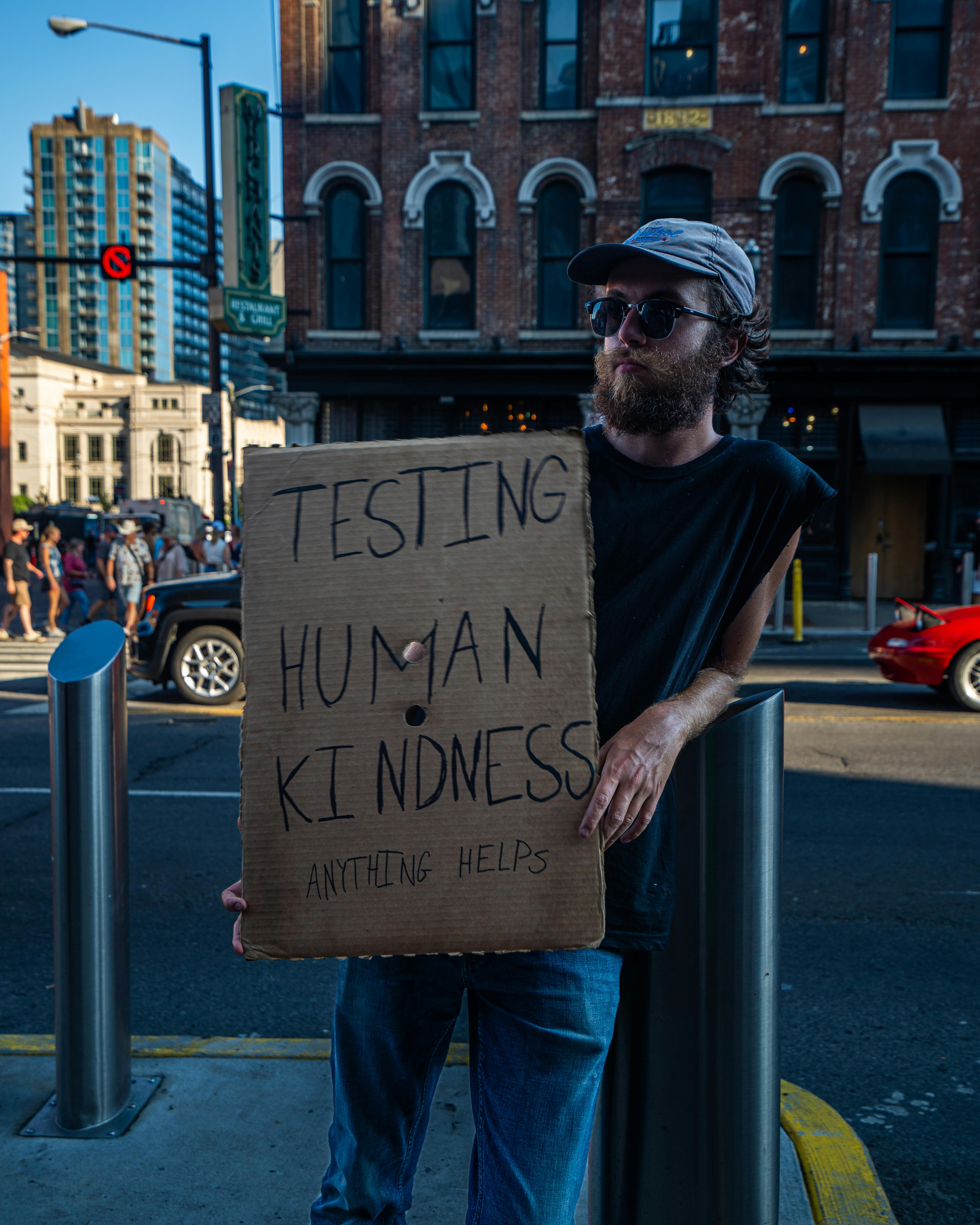 young homeless man with sign