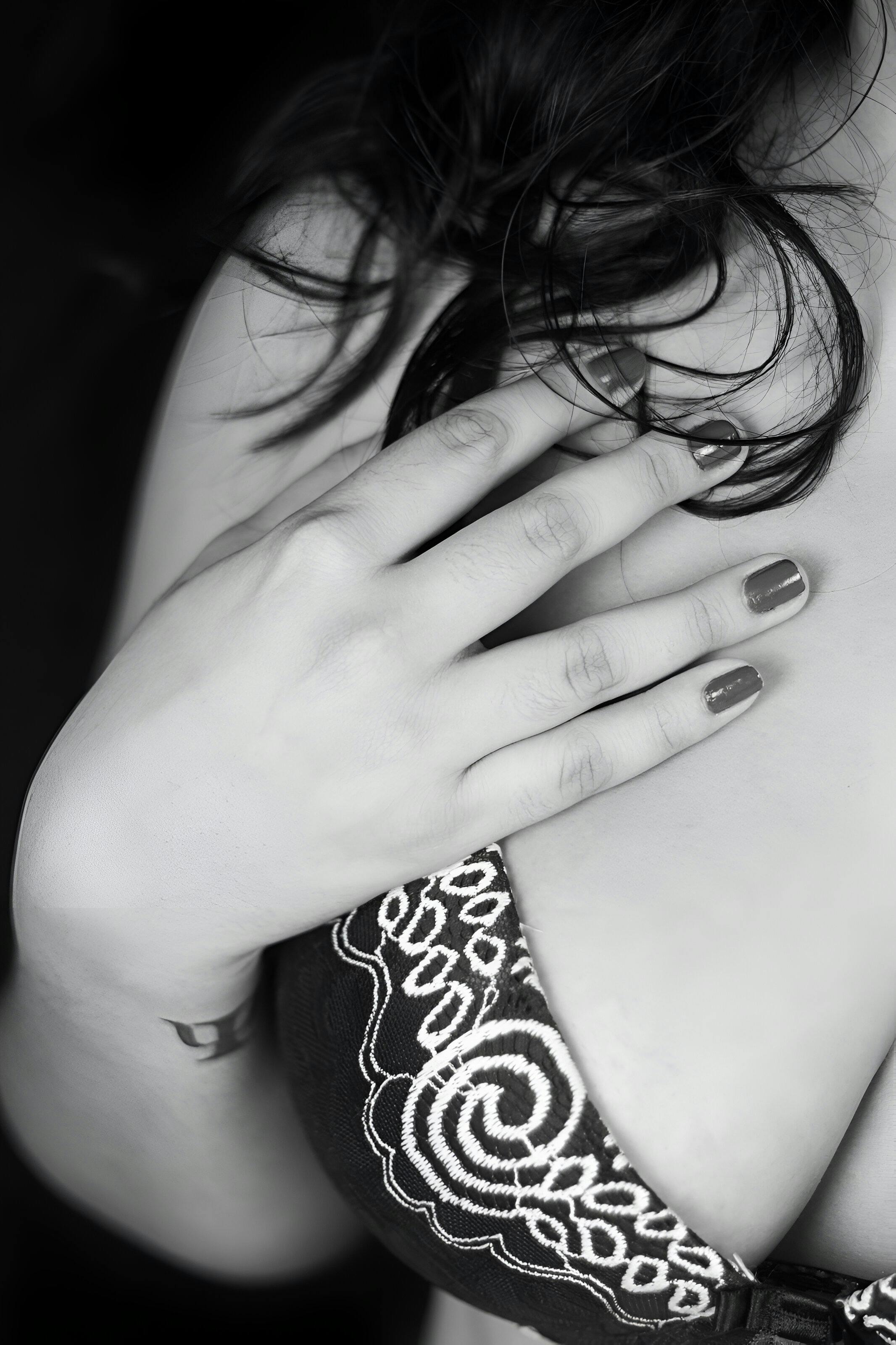 a woman with her hands on her chest in black and white