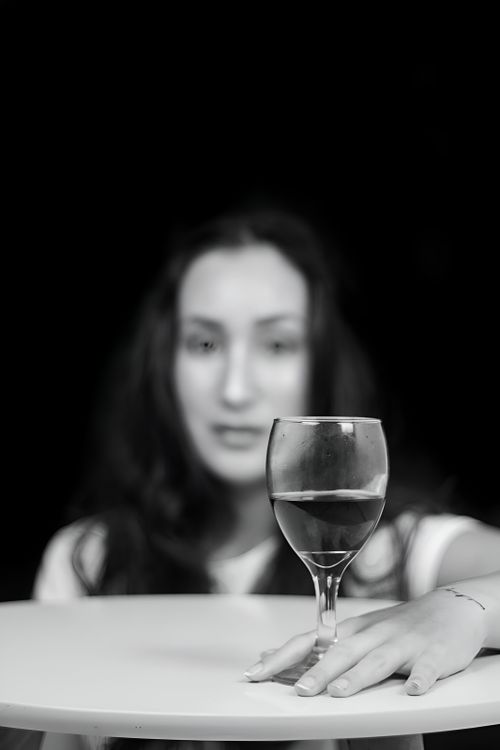 Free Elegant black and white portrait featuring a woman with a focus on a wine glass. Stock Photo