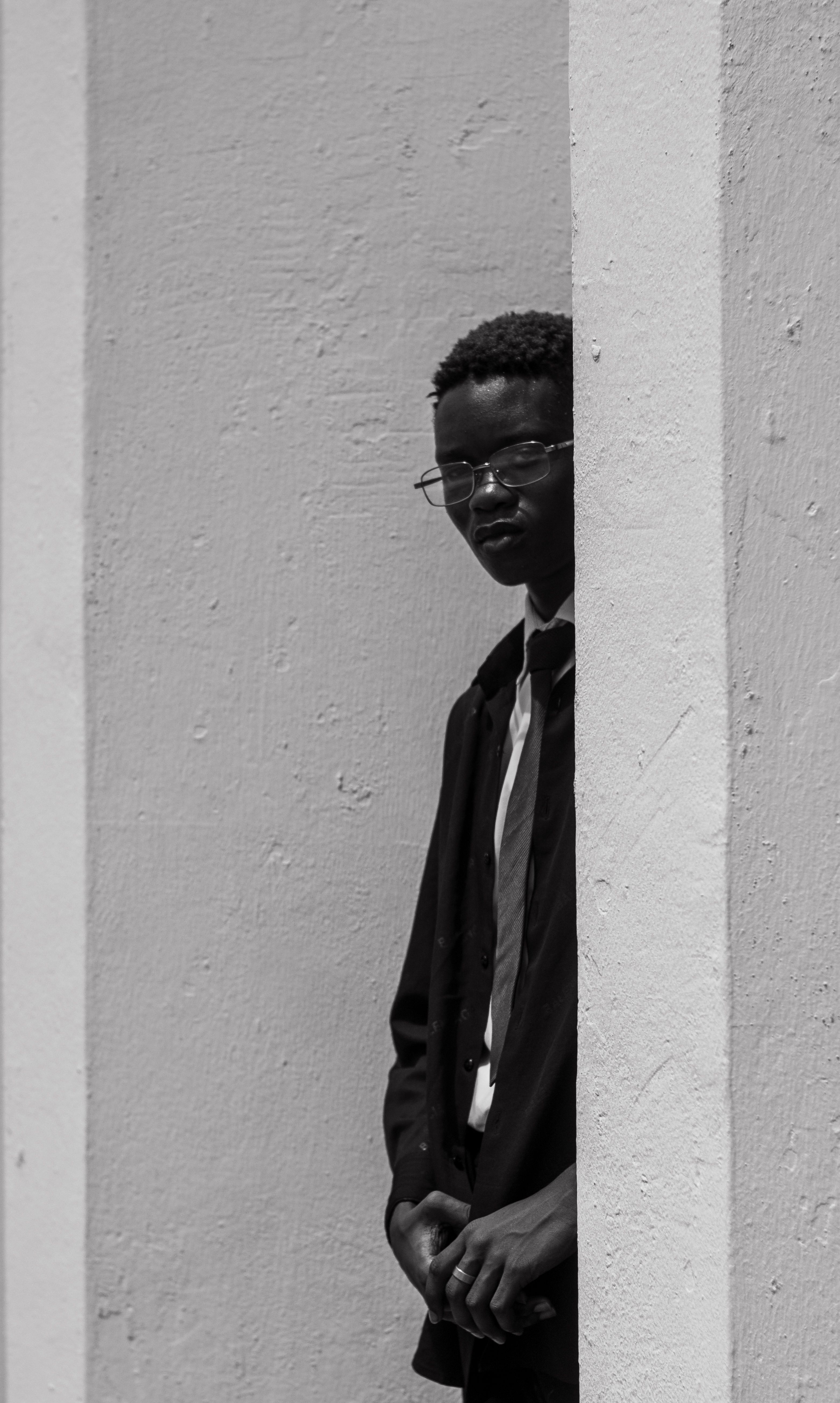 A man in a suit and tie leaning against a wall · Free Stock Photo