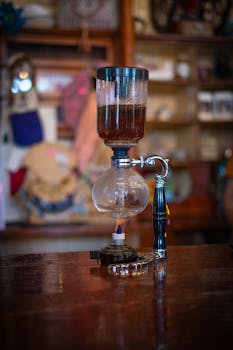 Siphon coffee maker brewing in a cozy café with a rustic interior.