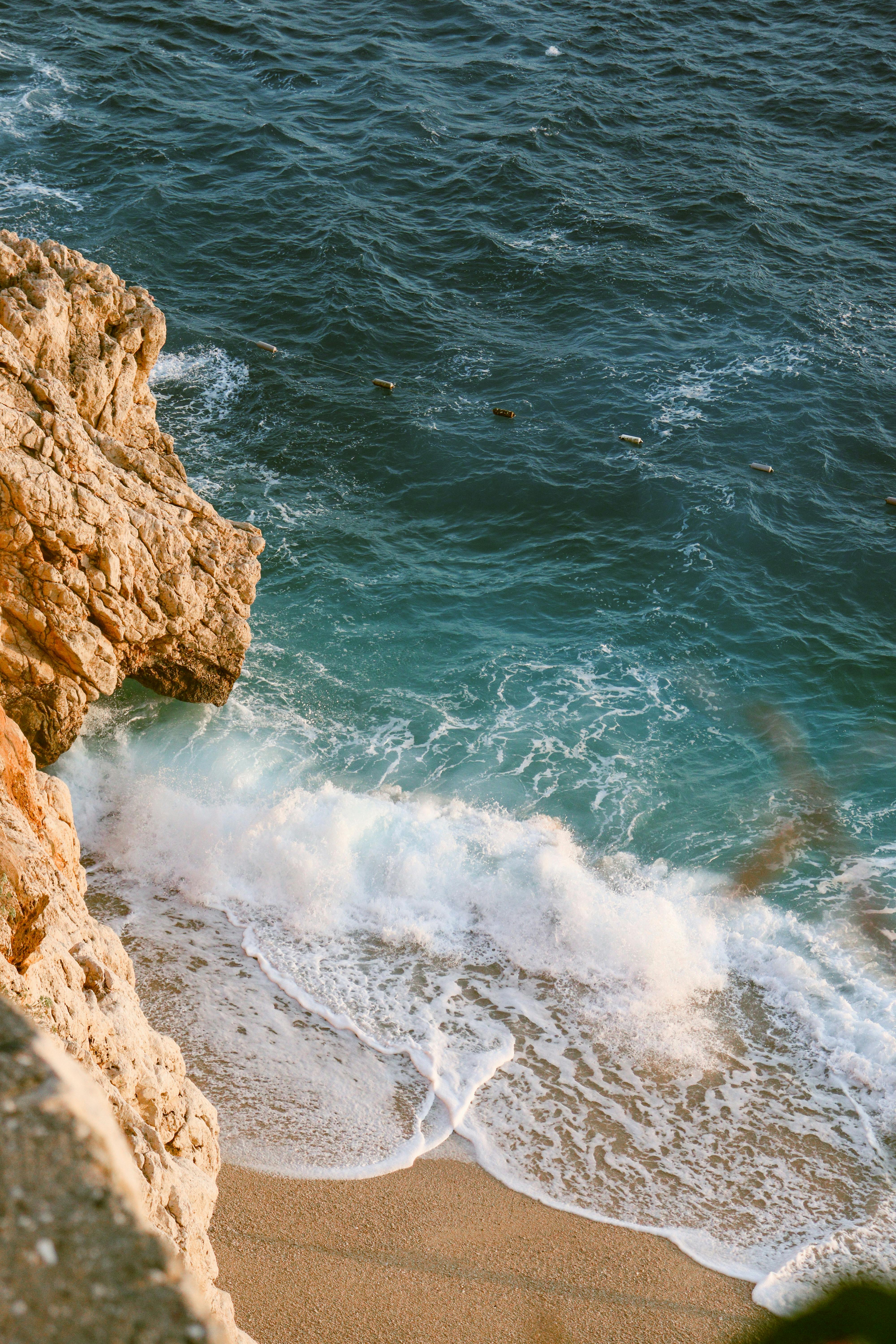 Beautiful coastline with cliffs and turquoise ocean waves crashing on the shore.