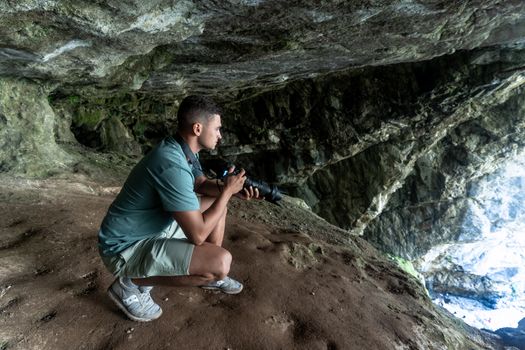 Photographer in a cave at Гагра, capturing the natural rock formations. Perfect for adventure and exploration themes.