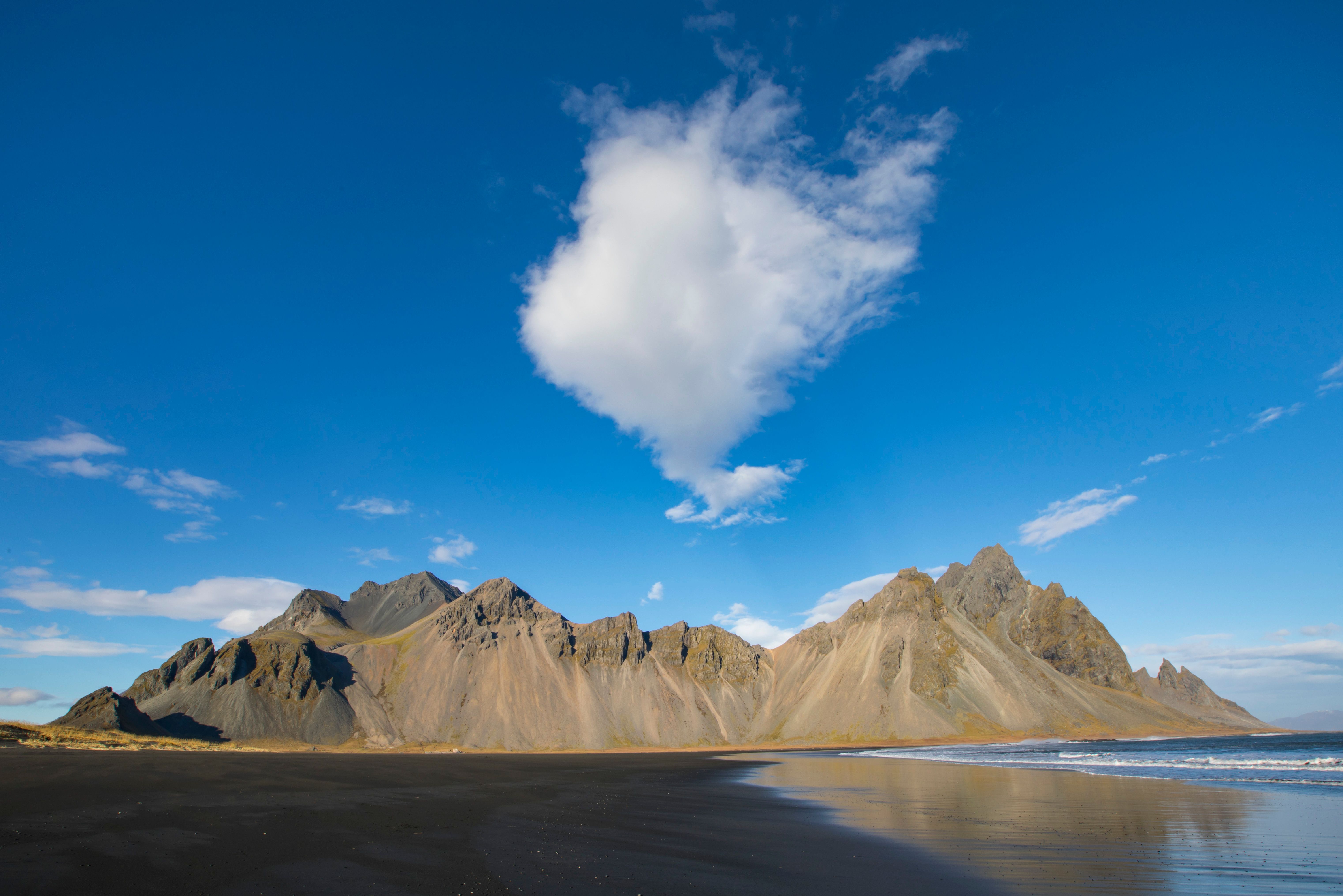 A beach with a large mountain in the background · Free Stock Photo