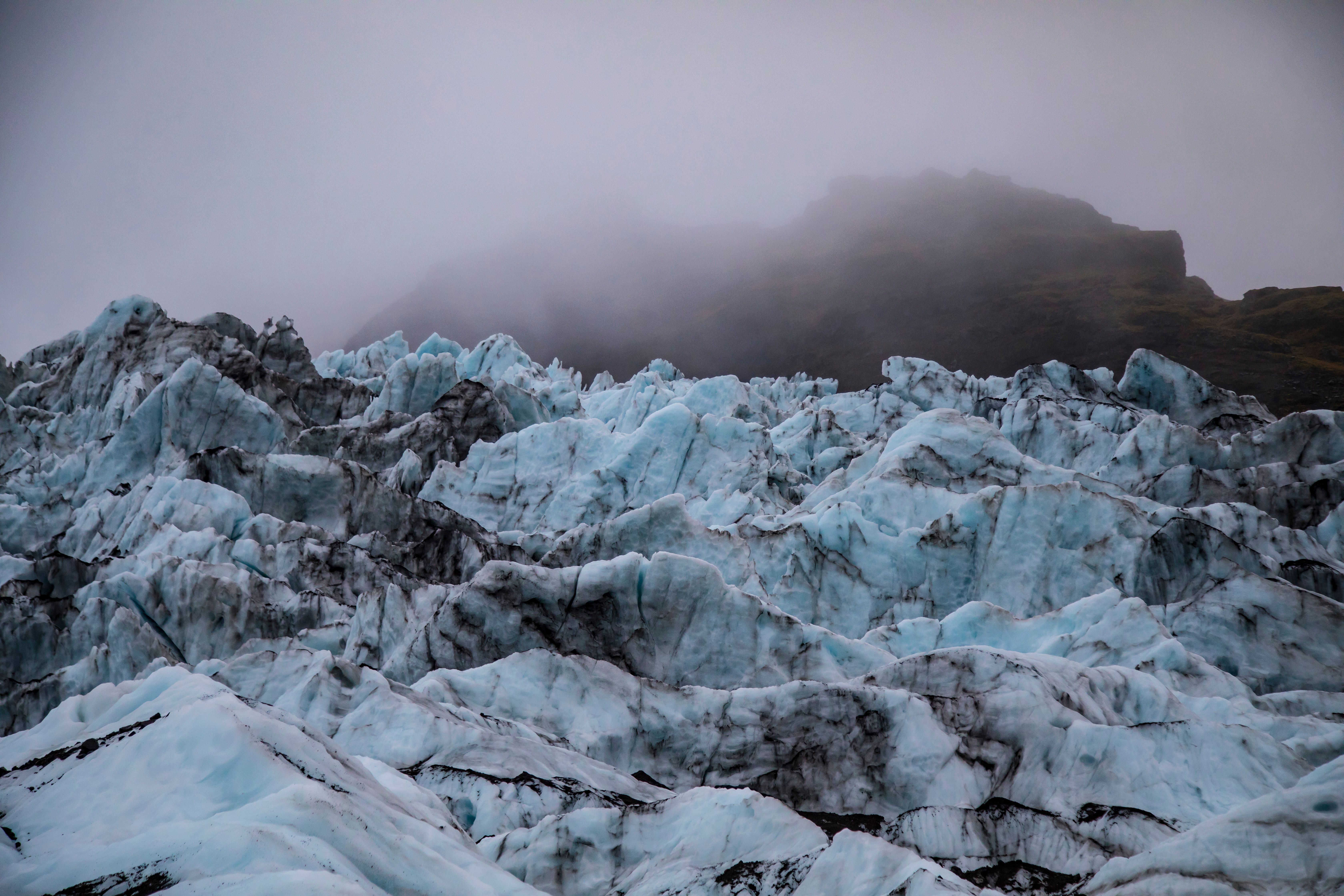 Stunning view of a frosty glacier with a mist-covered mountain in the background.