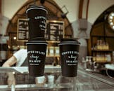 现代咖啡馆里，三个时尚的一次性咖啡杯散发着温暖和舒适的气息