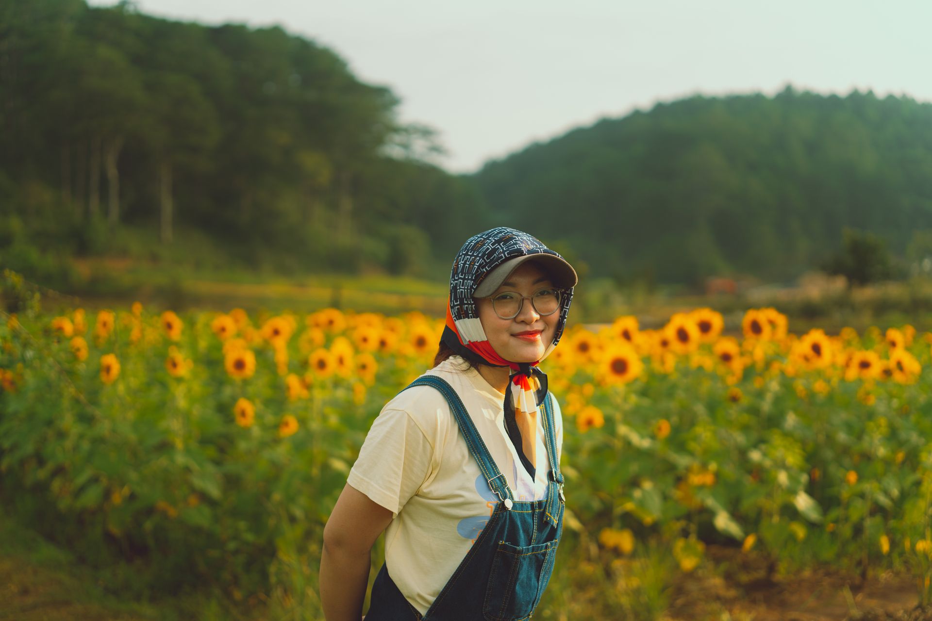 A woman stands smiling in a vibrant sunflower field in Dalat, capturing the essence of Vietnamese countryside.