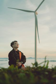 Man enjoying tranquility near a wind turbine in Dalat, Vietnam.