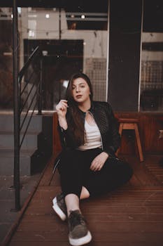 一位黑发年轻女子身着休闲装，在室内的木地板上摆姿势