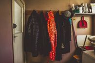 Hanged Black and Orange Coats Inside Room