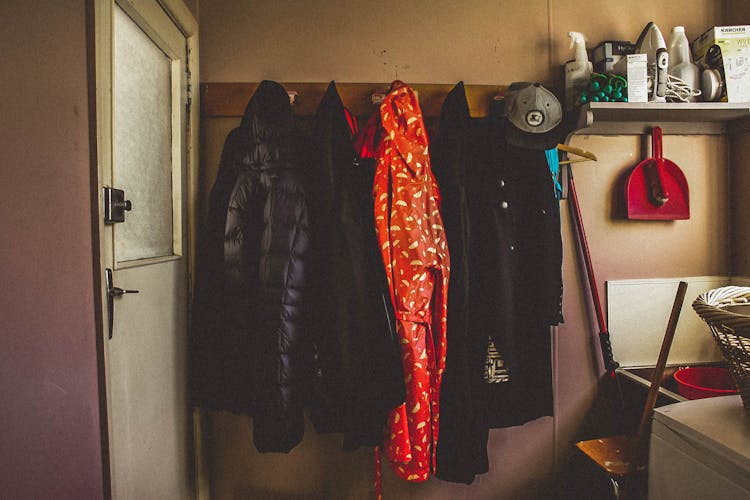 Hanged Black And Orange Coats Inside Room